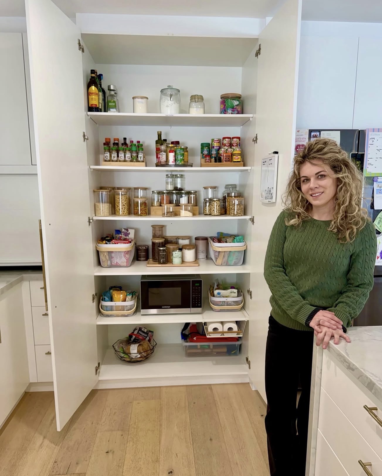 Vesna beside a beautifully organised kitchen pantry